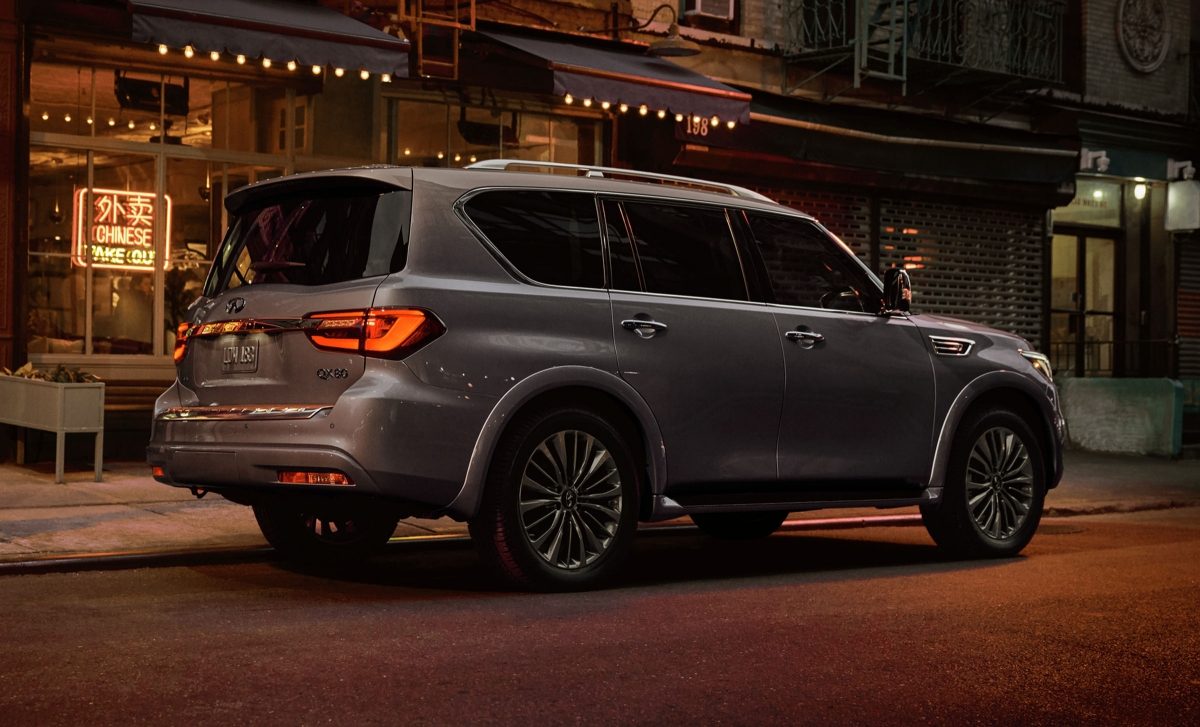 Angled view of a dark grey 2024 INFINITI QX80 7-8 passenger SUV parked on the street