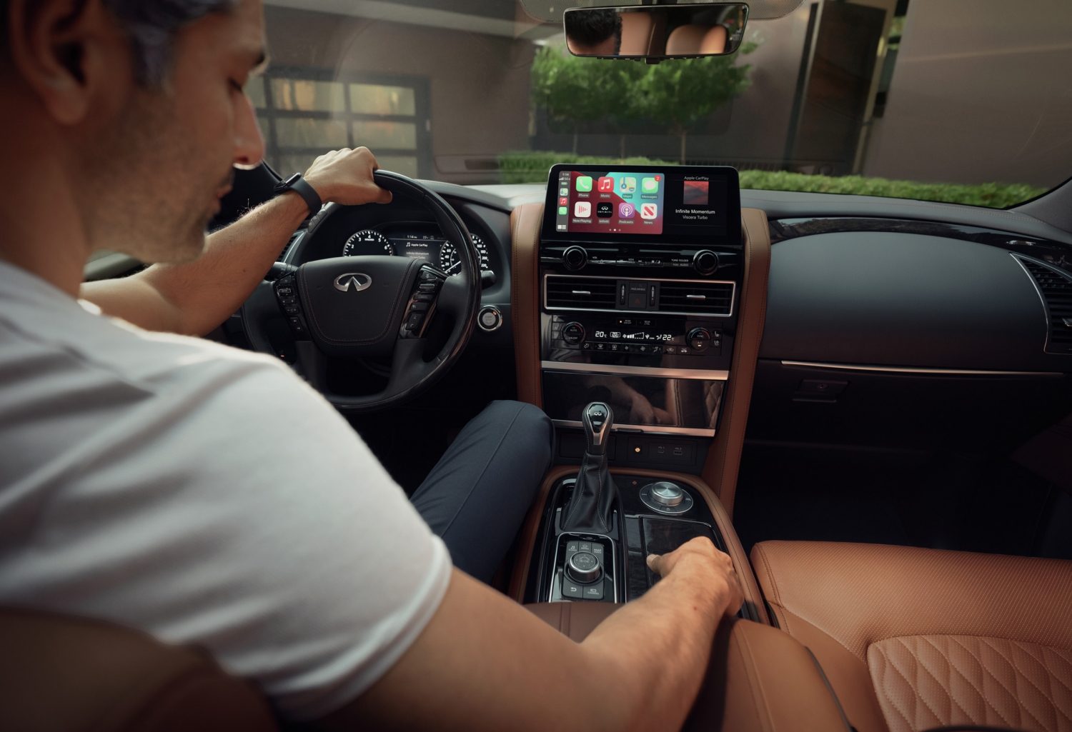 Driver turning the dial in the 2024 INFINITI QX80 7-8 passenger SUV