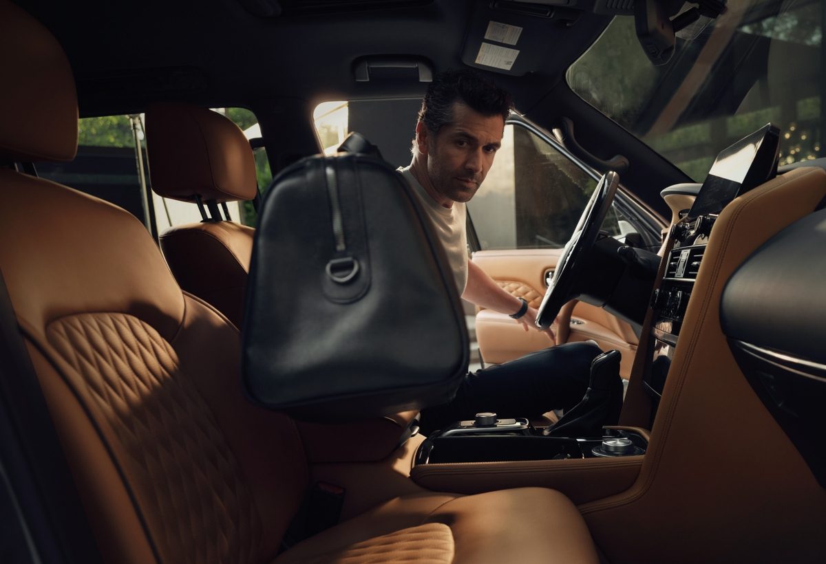 Driver getting into the front seat of the 2024 INFINITI QX80 7-8 passenger SUV