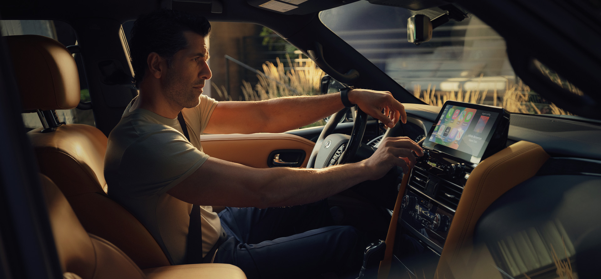 Driver adjusting volume in the 2024 INFINITI QX80 7-8 passenger SUV