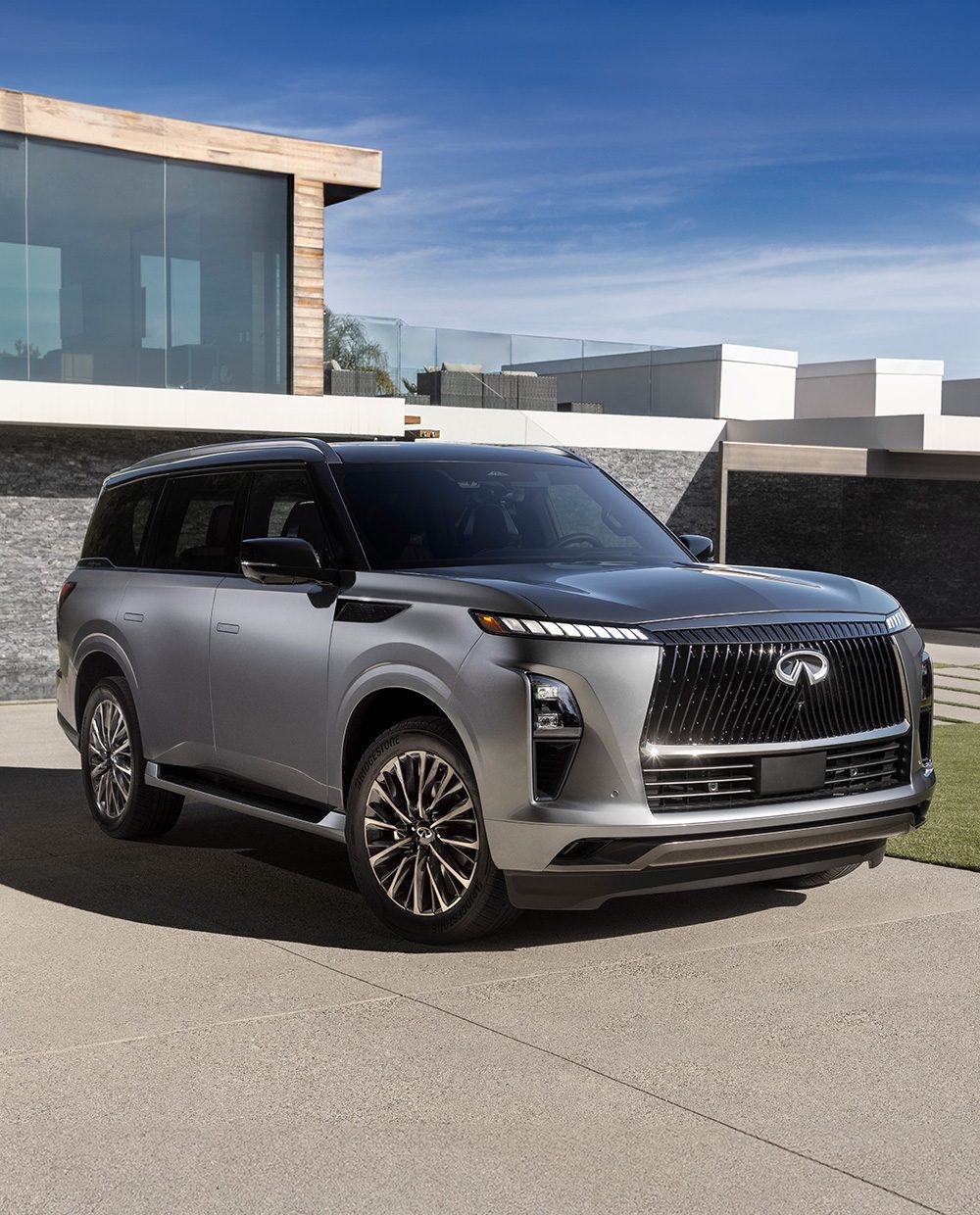 Angled view of the all-new 2025 INFINITI QX80 SUV parked on a driveway