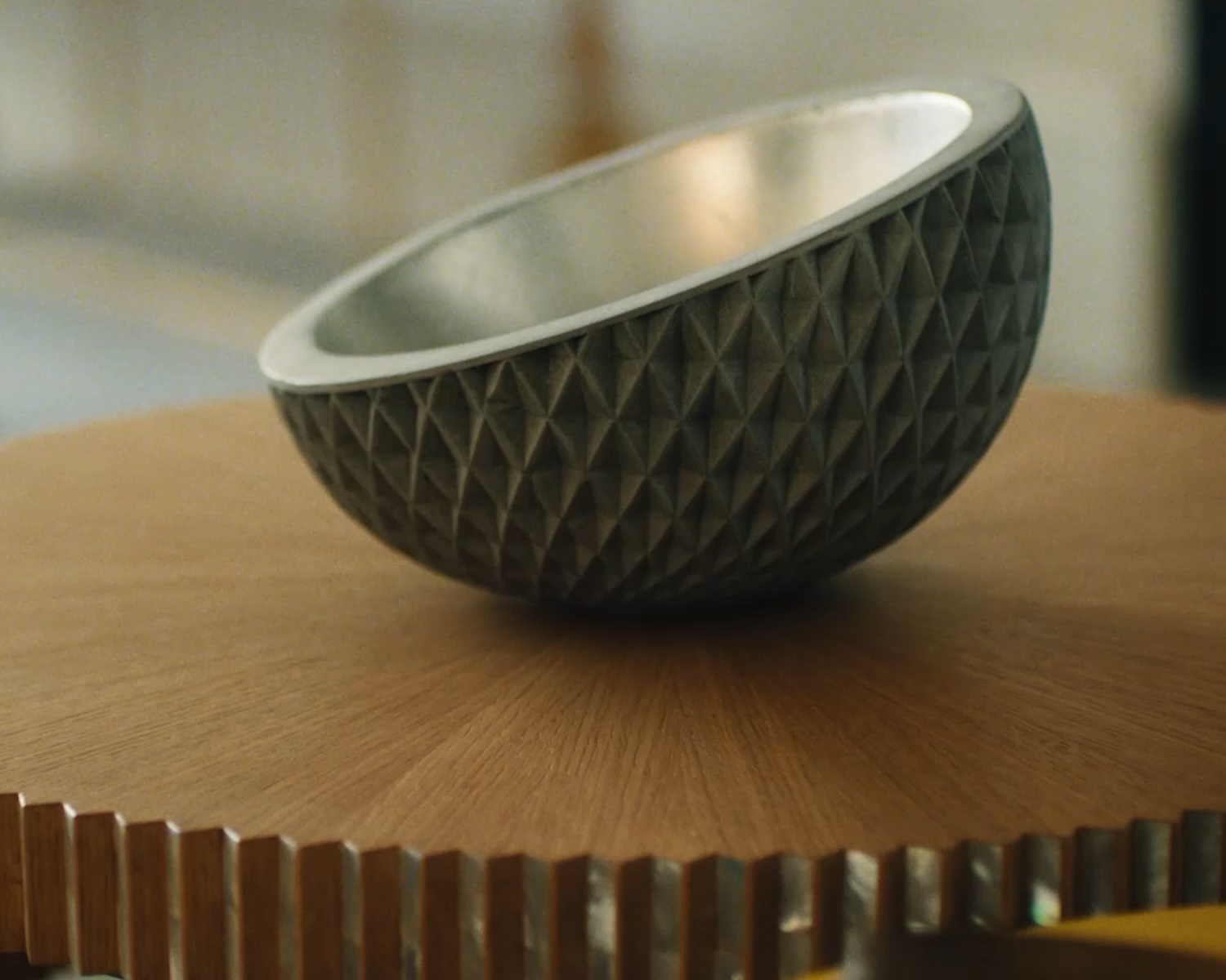 A decorative bowl resting on a wooden surface illustrating INFINITI design