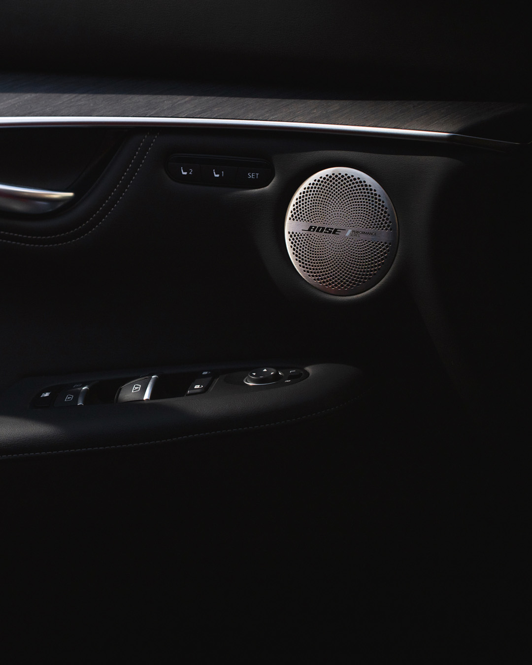 Primer plano de la rejilla del altavoz Bose en el panel de la puerta delantera del QX55