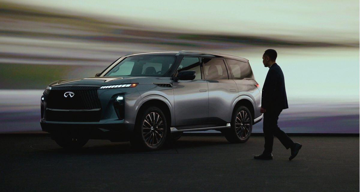 Designer walking towards INFINITI QX80 full-size luxury SUV