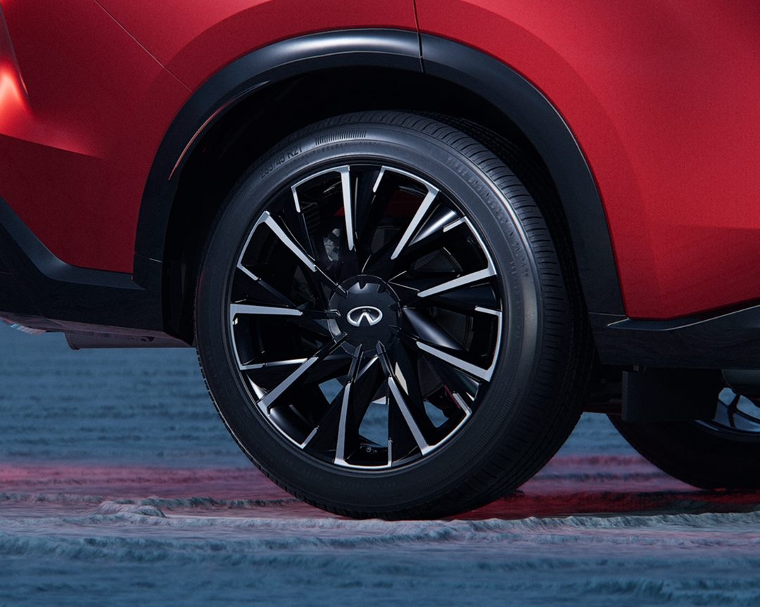 Close-up of INFINITI QX65 alloy wheels with intricate spoke design