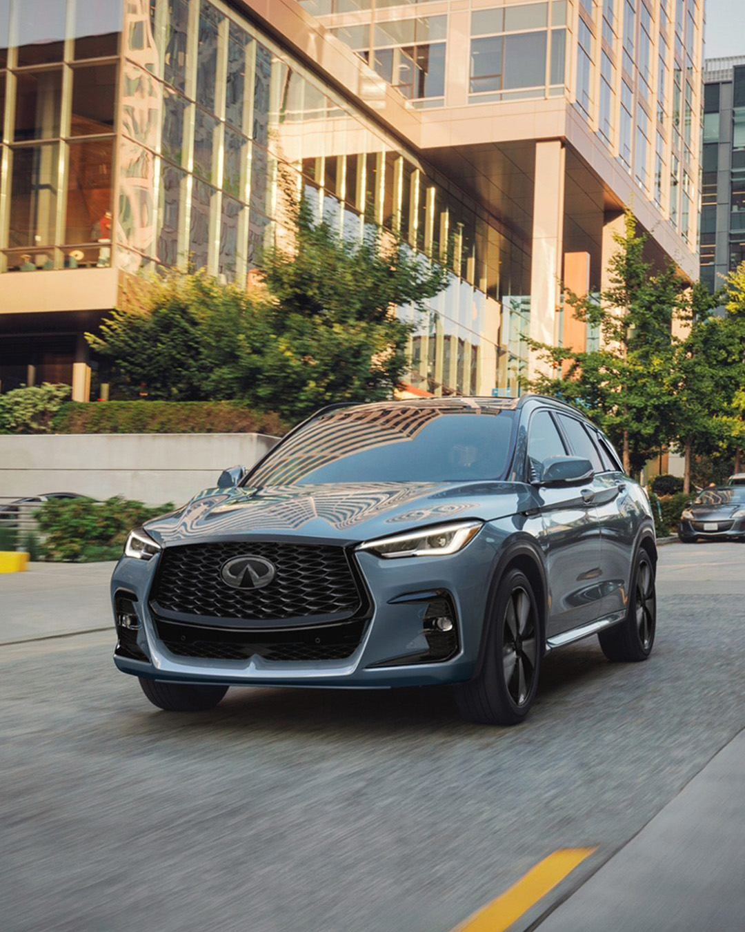 INFINITI QX50 compact SUV driving through modern city environment