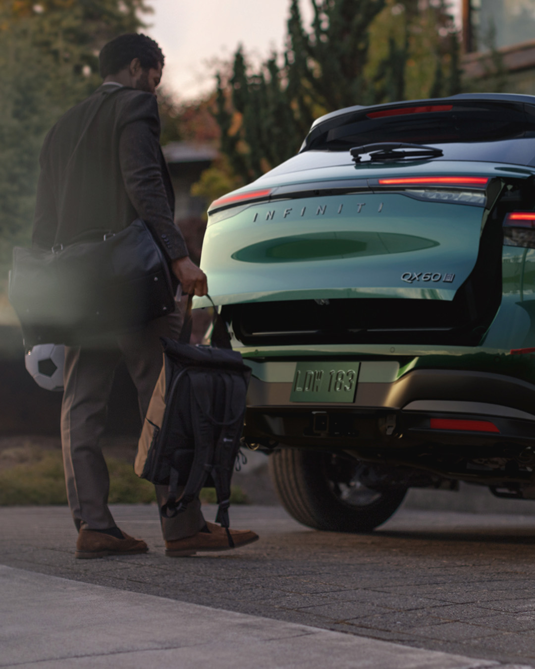 Motion-activated liftgate on 2027 INFINITI QX60 opening while driver approaches with gear