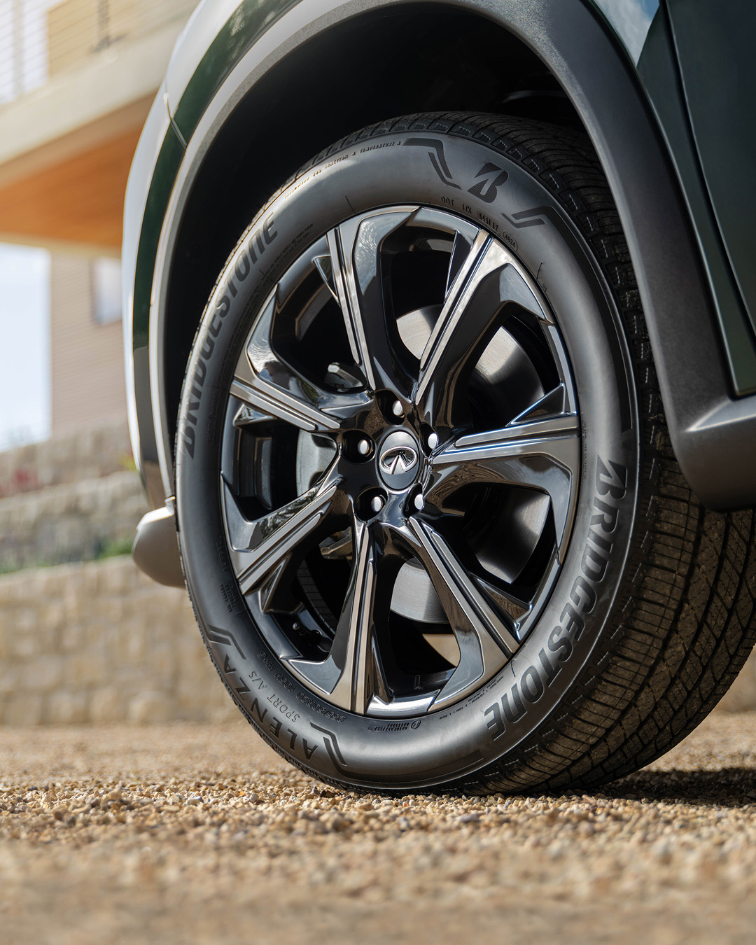 Close-up of 2027 INFINITI QX60 gloss black 20-inch alloy wheel with Bridgestone tire