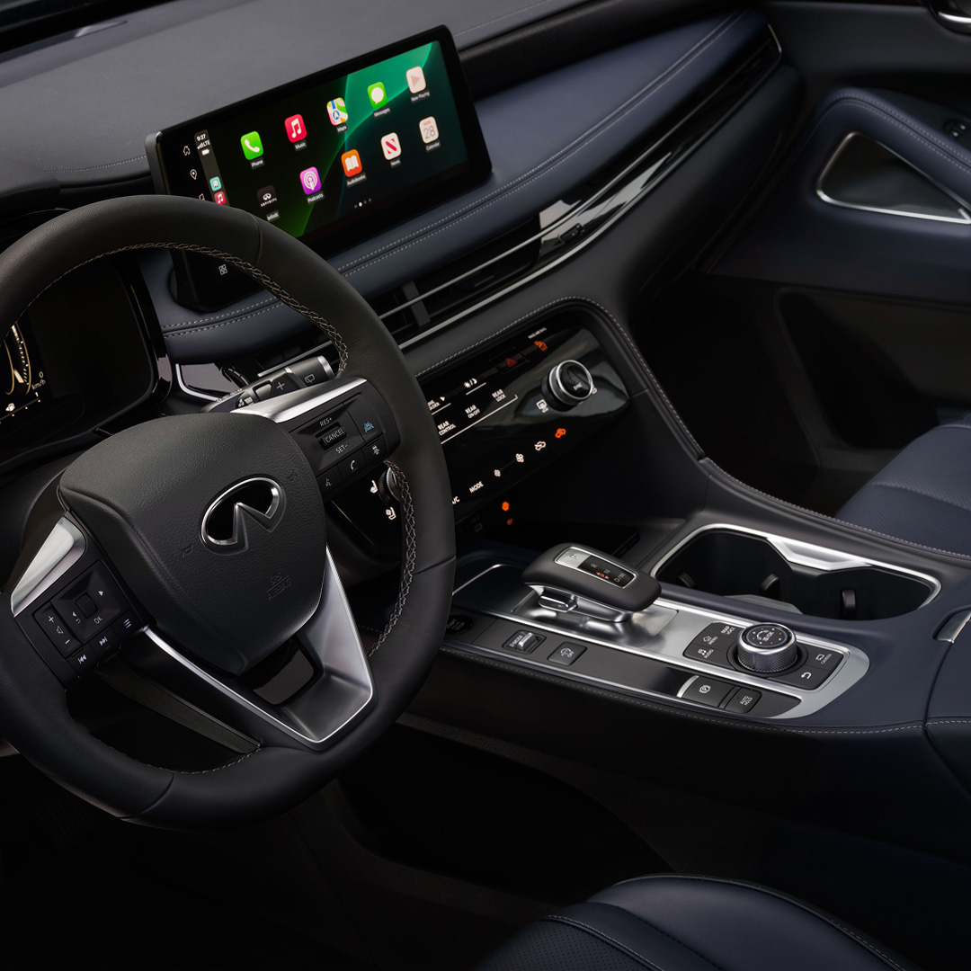Interior view of 2027 INFINITI QX60 featuring infotainment touchscreen with smartphone connectivity and rotary gear selector