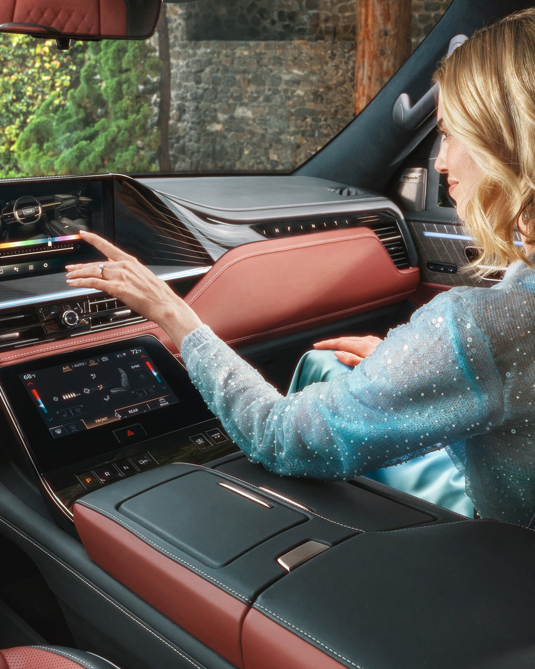 Woman interacting with INFINITI vehicle touchscreen inside cabin and using INFINITI IQ Technologies