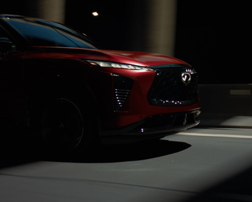 Driver experiencing the refined performance and sound enhancement features of the 2027 INFINITI QX65