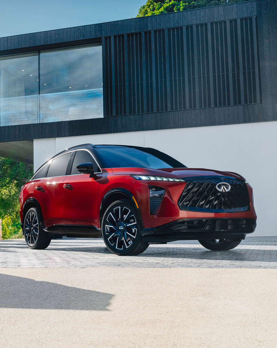 Red INFINITI QX65 sportback SUV parked outside a modern building