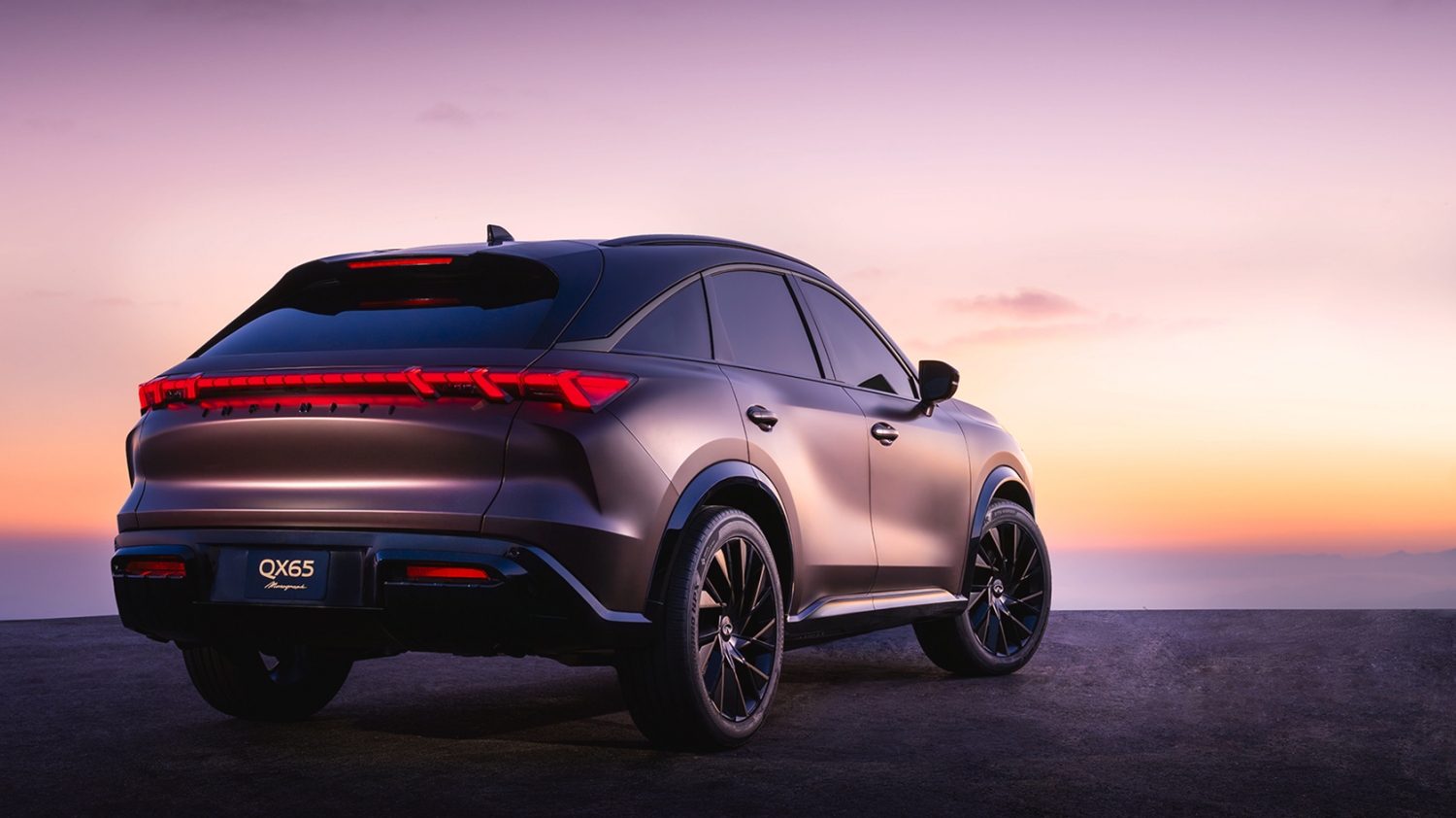 INFINITI QX65 monograph viewed from the rear at sunset