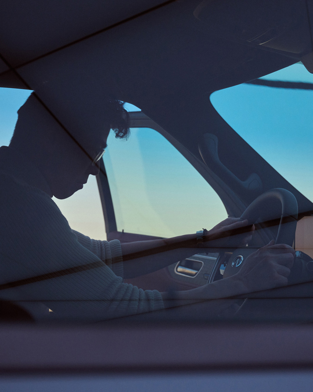 Driver inside INFINITI vehicle focusing on road and driving experience