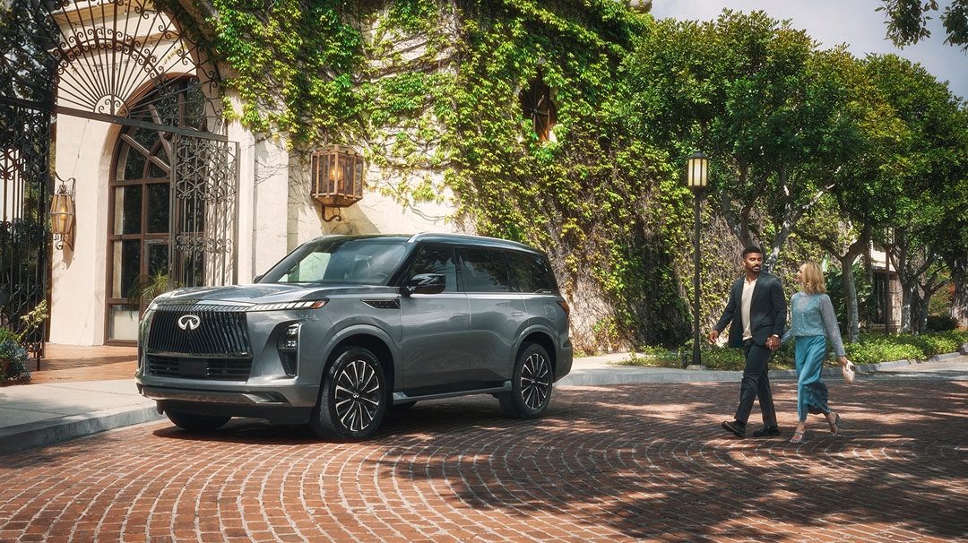 INFINITI luxury SUV parked in upscale residential setting with people walking nearby