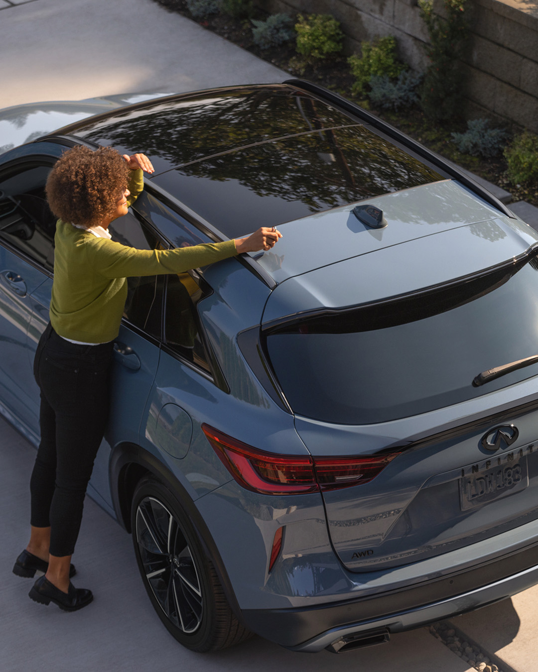 Persona interactuando con el techo de un automóvil INFINITI, representando actualizaciones sobre noticias y eventos de la marca.