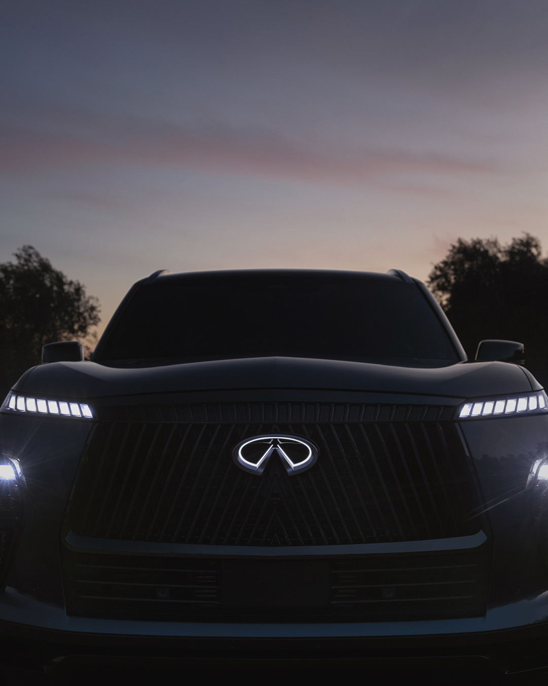 Vista frontal del coche INFINITI al anochecer