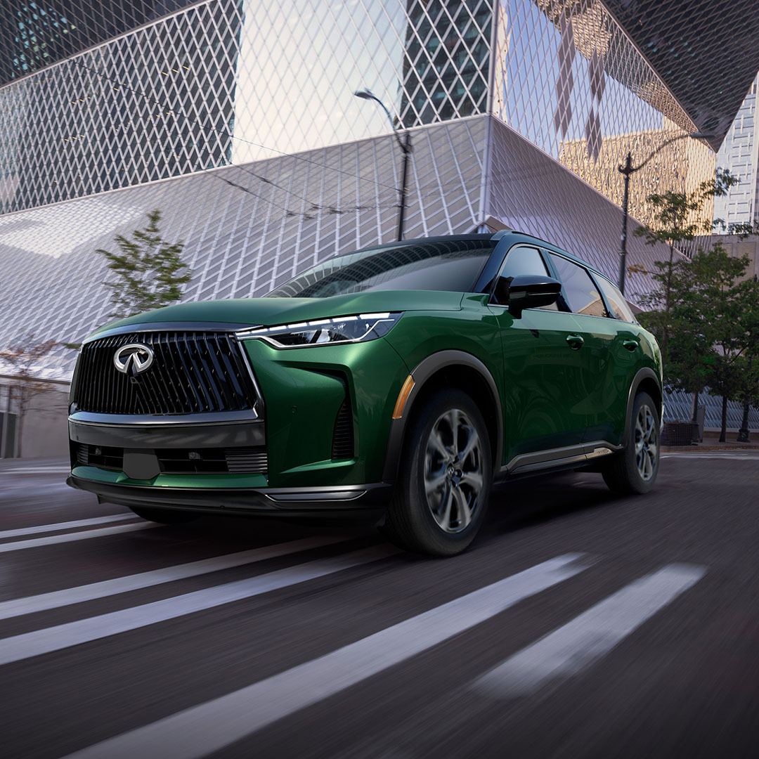 INFINITI QX60 in motion through city streets, highlighting world-first engine technology