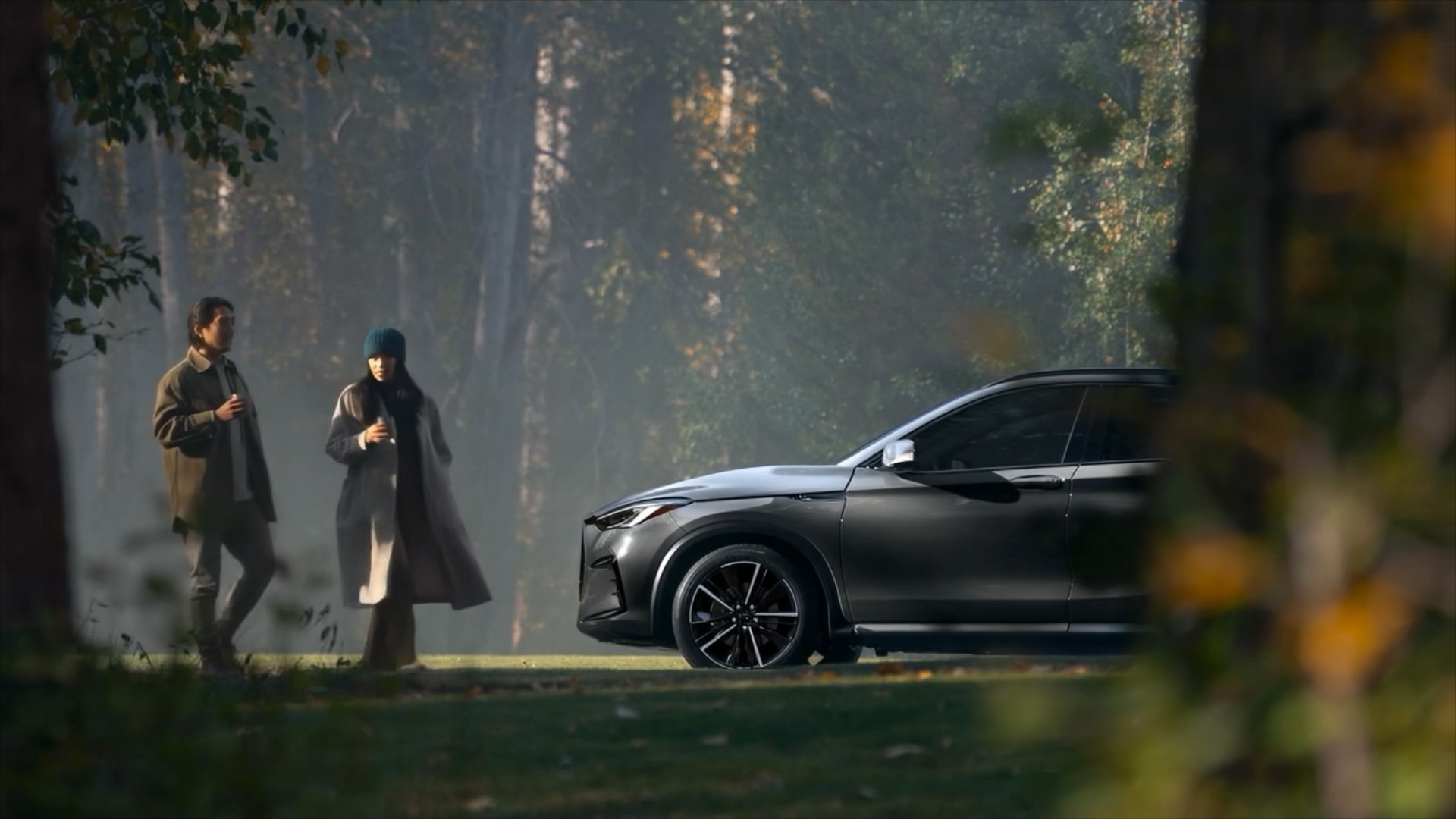 Video of couple walking near an INFINITI QX50 in a park