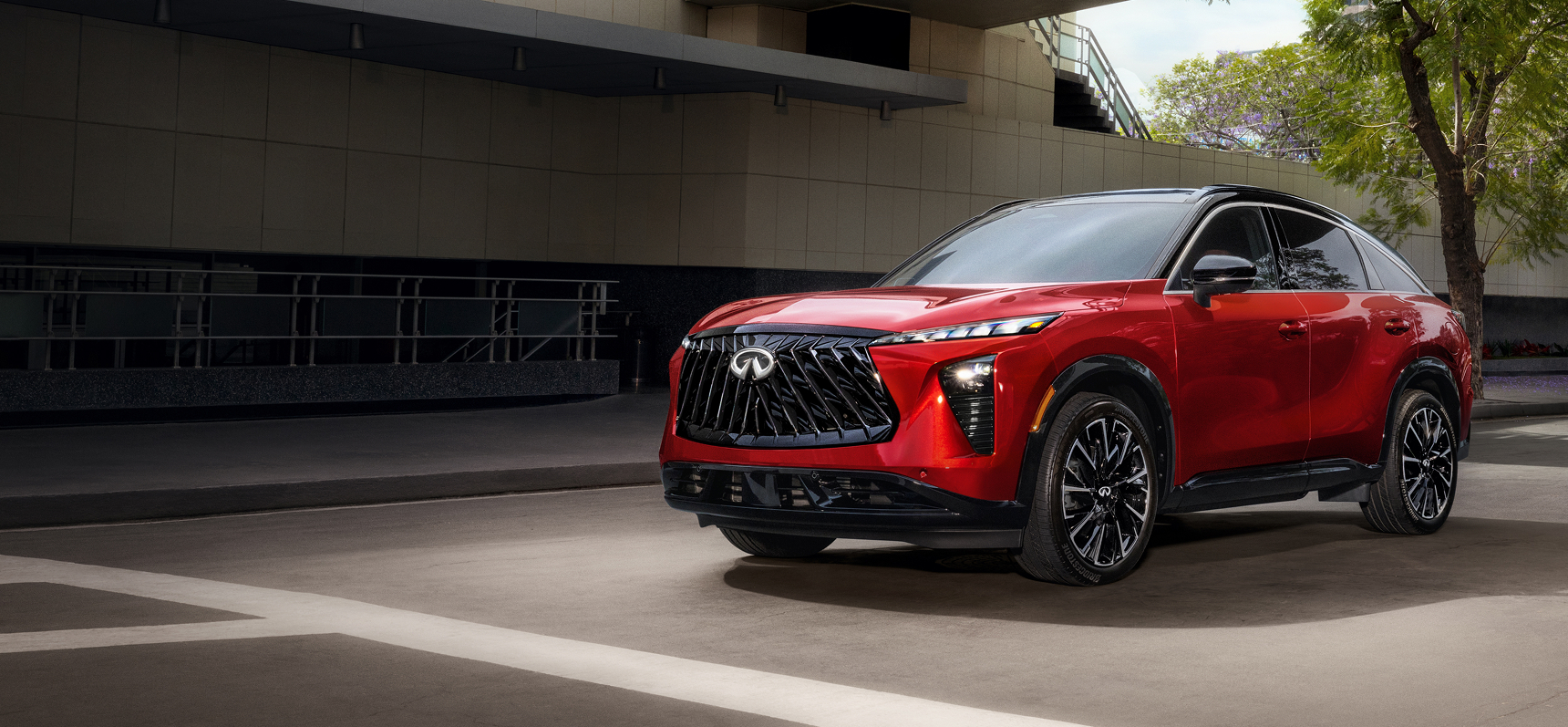 Red INFINITI QX65 luxury crossover parked in a modern urban setting