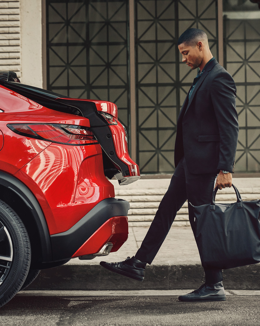 INFINITI QX55 hands-free liftgate loading luggage into the cargo area
