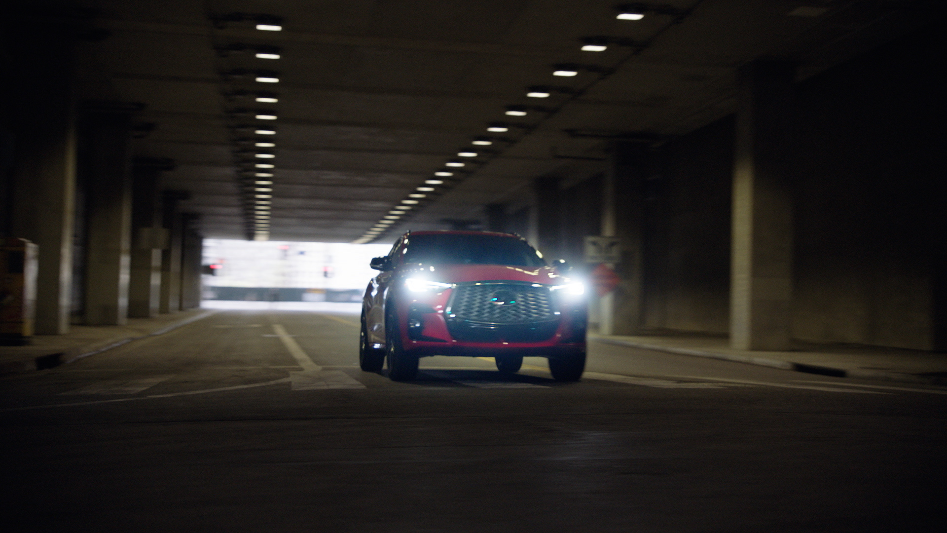 INFINITI QX55 luxury crossover driving through a city tunnel