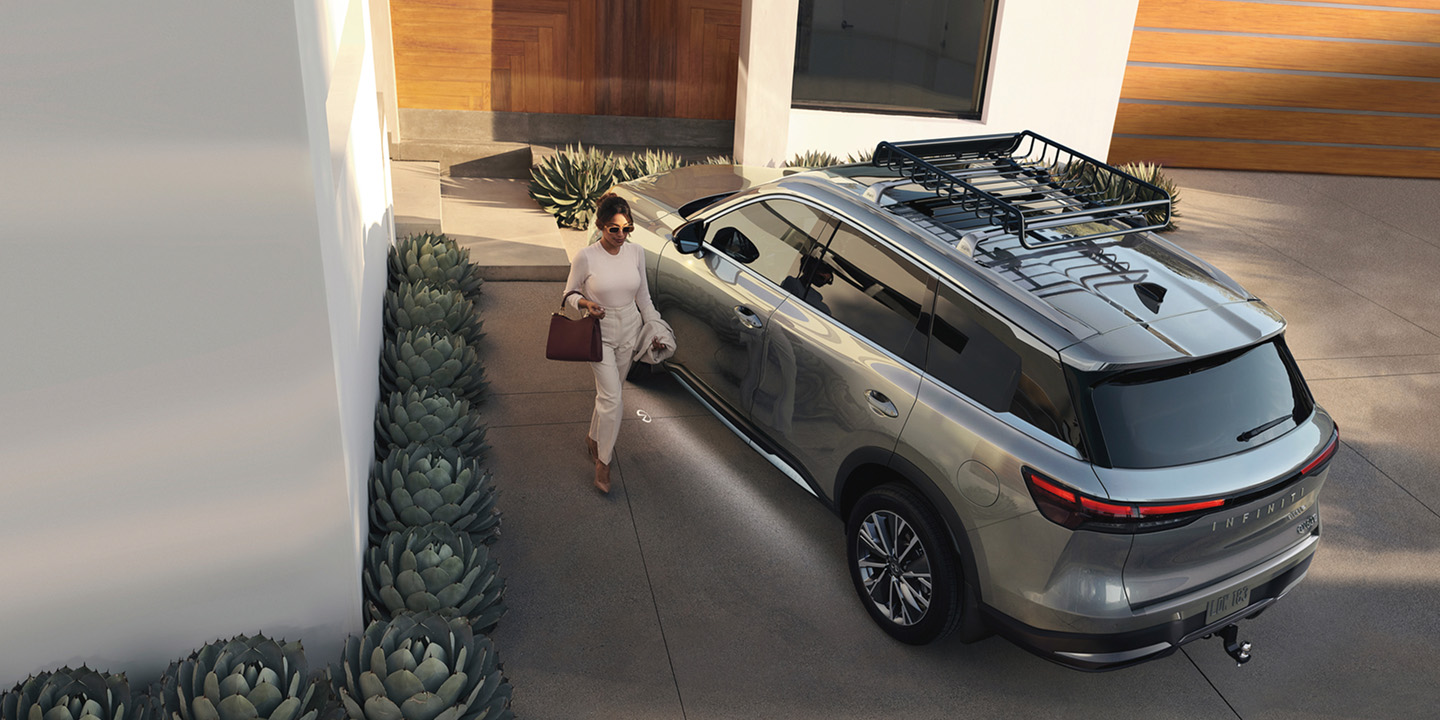 Conductor junto a una SUV INFINITI QX60 de 7 plazas