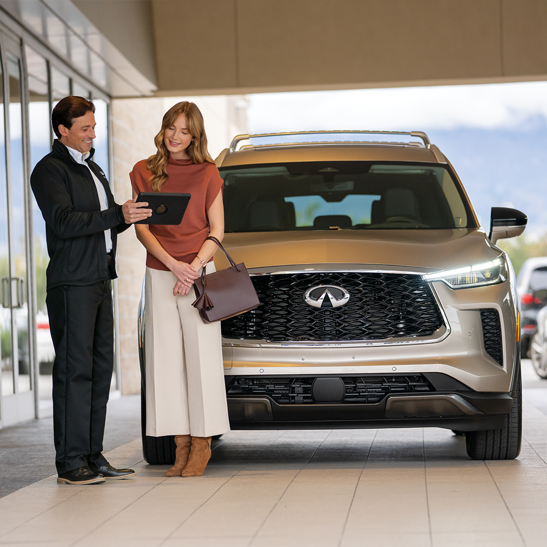 Experto de servicio atendiendo a una mujer para el mantenimiento de su QX60