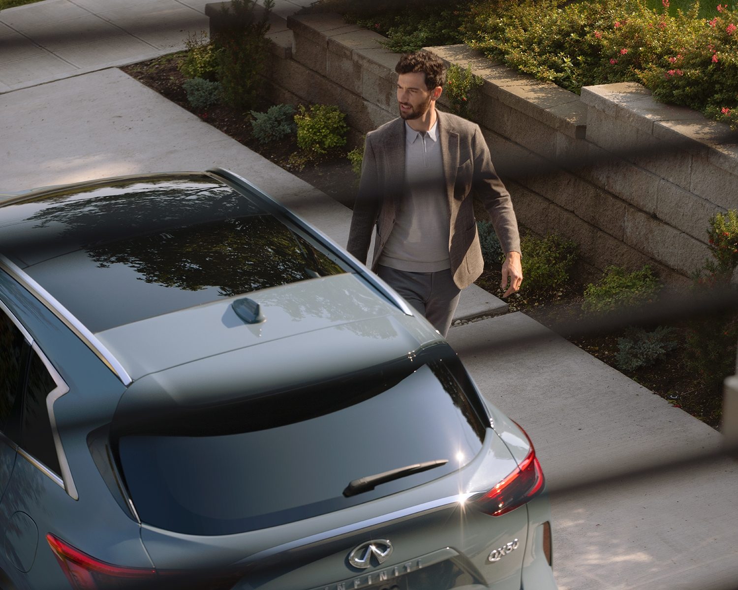 Hombre caminando a un lado de su QX50
