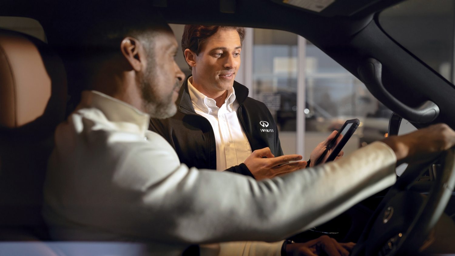 Experto en servicio, hablando con un cliente abordo de su INFINITI
